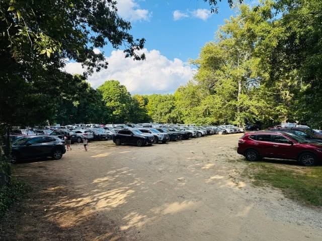 View of horse paddock and open field from visitor parking